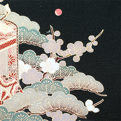暗い背景に、金色とパステルカラーの枝、様式化された雲、小さなピンクの円をあしらった伝統的な日本のデザインを特徴とする織物のクローズアップ。.
